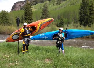 Two Kayakers holding their gear